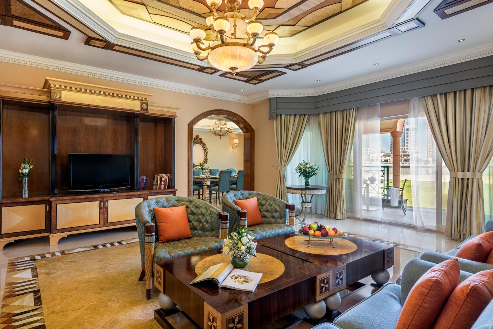 אבו דאבי Al Raha Beach Resort & Spa מראה חיצוני תמונה The photo depicts a luxurious living room with elegant decor. It features two green upholstered sofas accented with orange pillows, arranged around a stylish coffee table. The coffee table showcases decorative items, including a magazine and a bowl o
