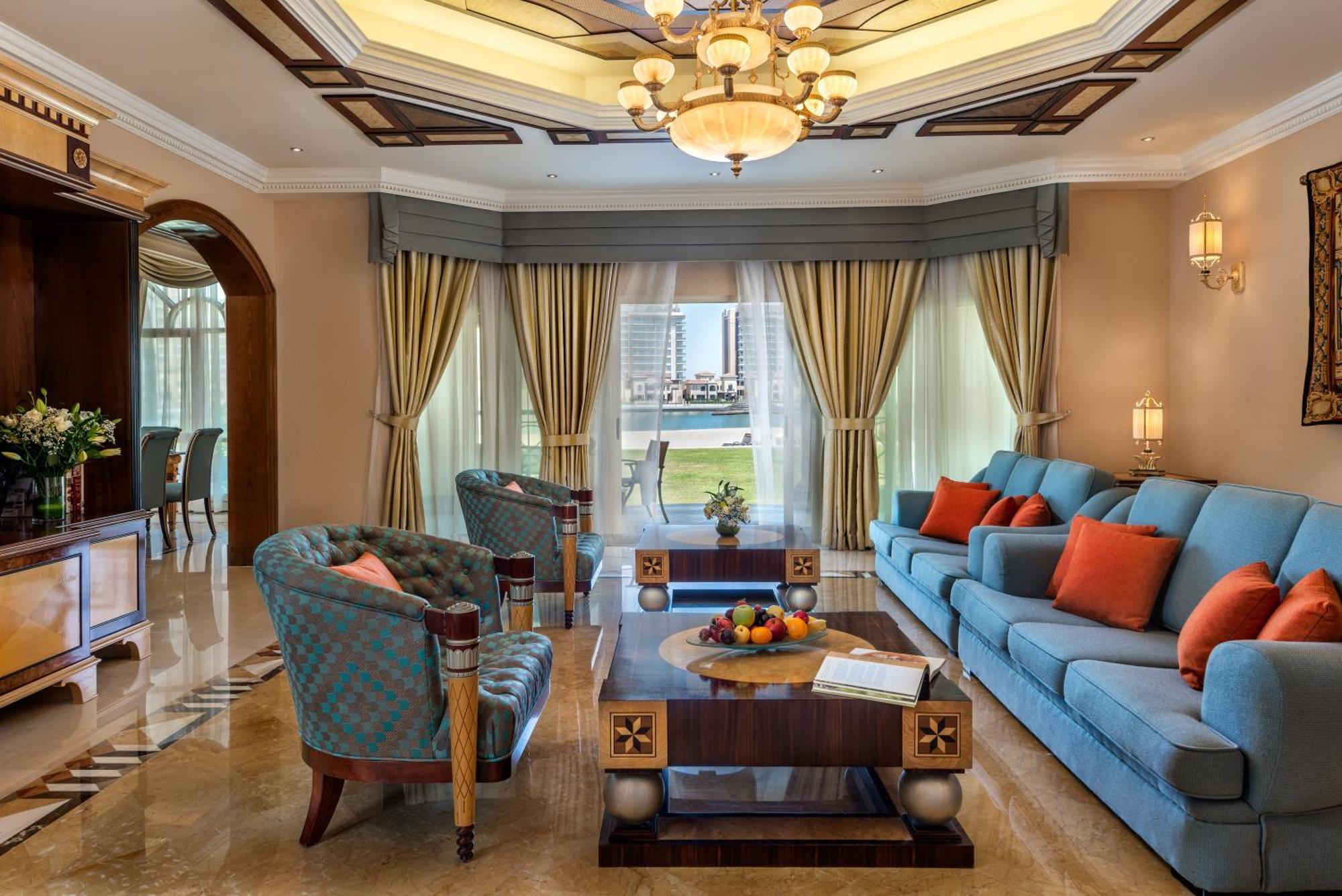 אבו דאבי Al Raha Beach Resort & Spa מראה חיצוני תמונה The photo depicts an elegantly designed living room with a sophisticated atmosphere. It features a large, light blue sofa adorned with orange and blue cushions. There are two stylish armchairs nearby with a unique pattern. In the center, a coffee tab